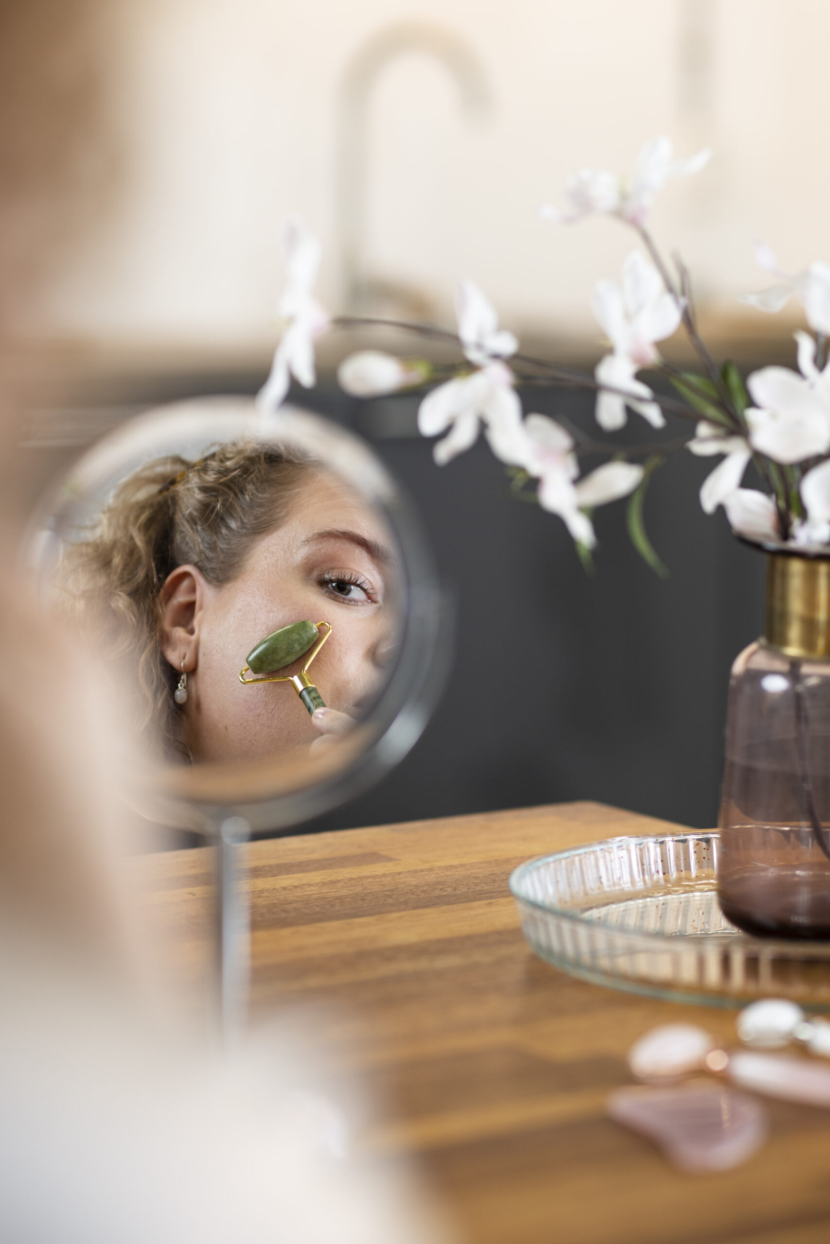 massage-du-visage-de-femme-dans-un-miroir-avec-gua-sha